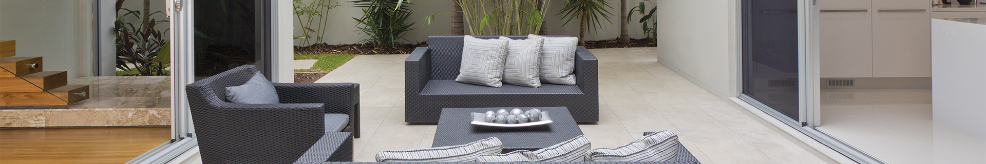 Outdoor area with couch, table and plants.