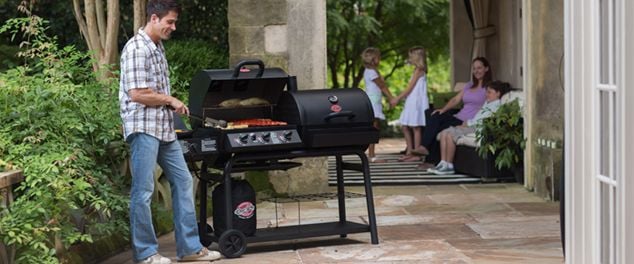 Man barbecuing sausages in backyard