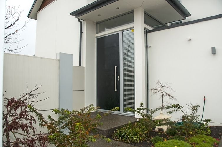 Exterior of a white townhouse with a dark grey front door.