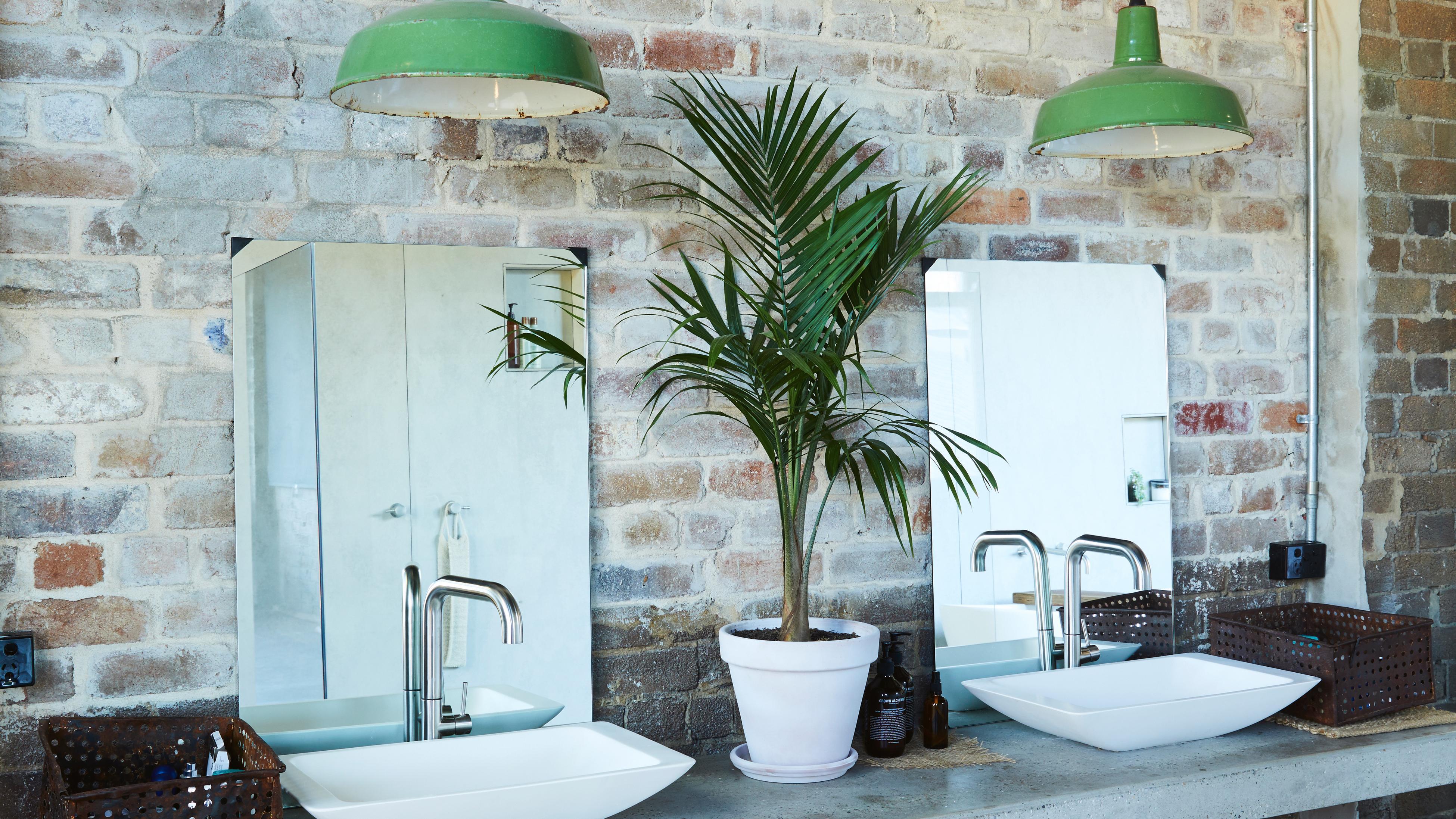 Exposed brick wall bathroom with two sinks