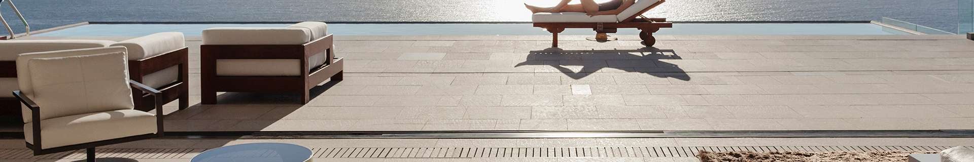 Outdoor area with cream paving, and outdoor setting.