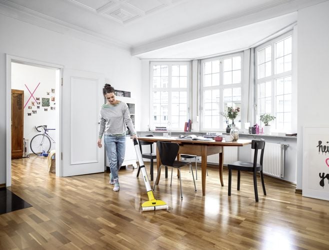 Woman using floor cleaner mop to clean floorboards