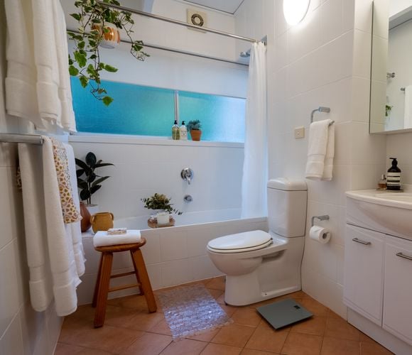 Bathroom interior with toilet, bath and stool