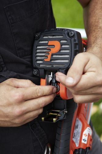 Person adjusting settings of nail gun