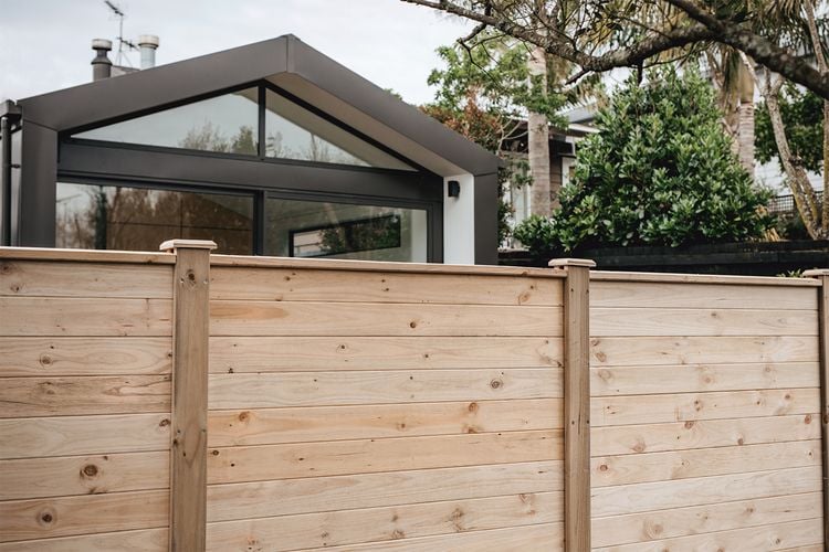 Tall laminated timber fence in front of house