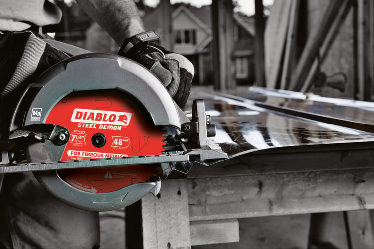 Person using circular saw to cut through metal