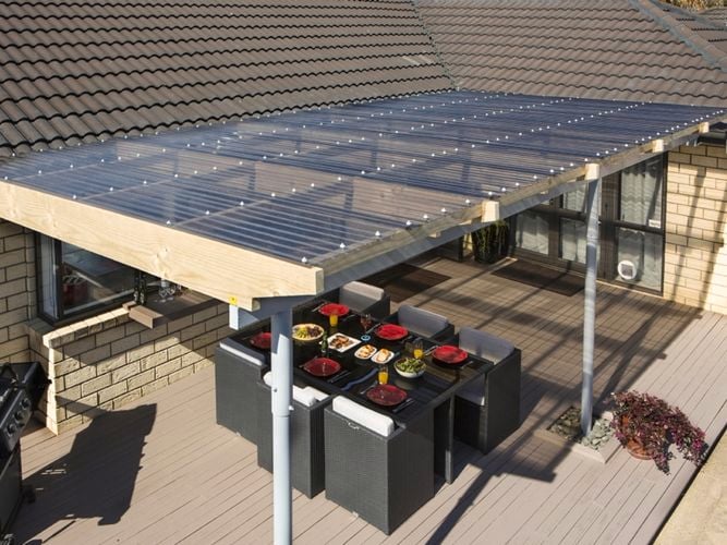 Outdoor entertaining area covered by an outdoor built structure with bronze tint suntuf