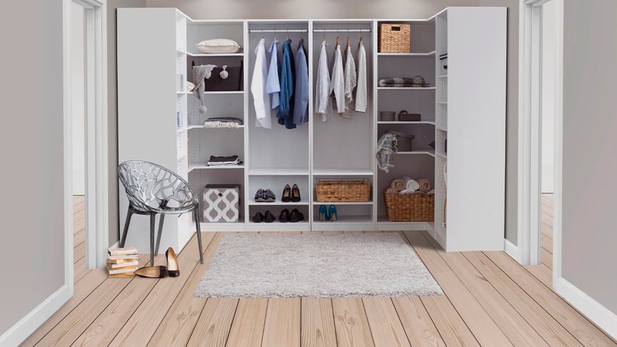 Organized walk in wardrobe with chair and rug. 