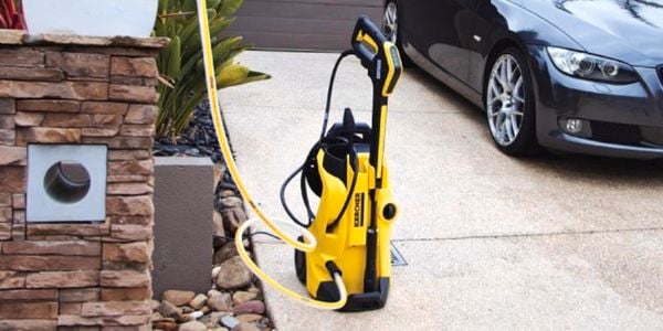 Kärcher pressure washer positioned in front of car