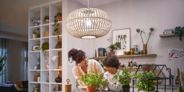 A lady and a young boy standing in the kitchen laughing