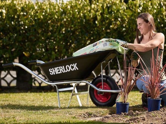 woman gardening and  cart besides her