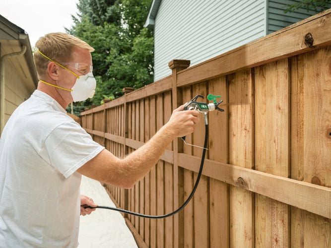Wagner
  Control Pro Hybrid Gun with HEA tip spraying a fence with brown paint