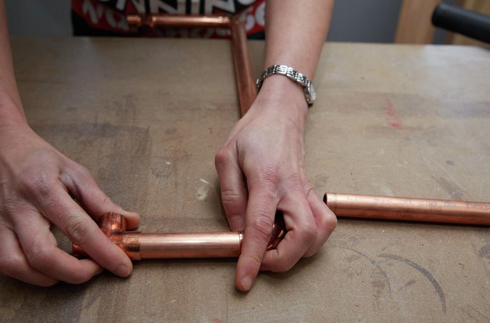 Person connecting copper pipe to copper joining