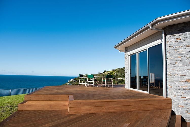 House exterior with timber decking and drainage pipe