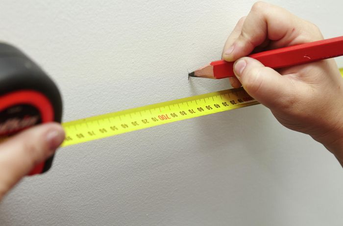 A pencil and tape measure used to measure out position for a wall flange
