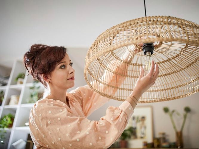 A lady changing a light globe