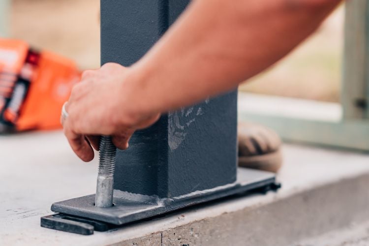 Person lining up metal beam during construction