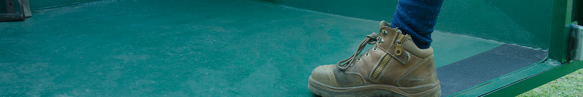 Work boot stepping on green tray