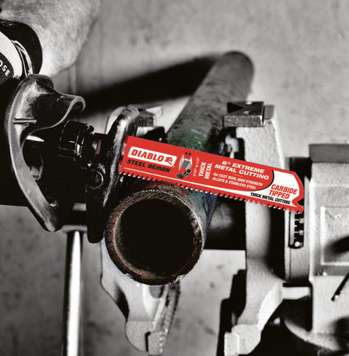 Reciprocating saw cutting through metal pipe