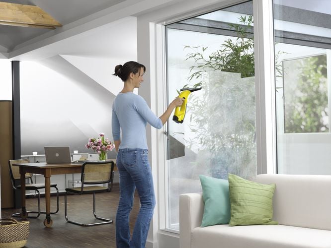 Woman using window vacuum to clean windows