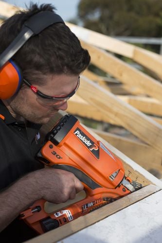 Person using nail gun to nail timber roof frame