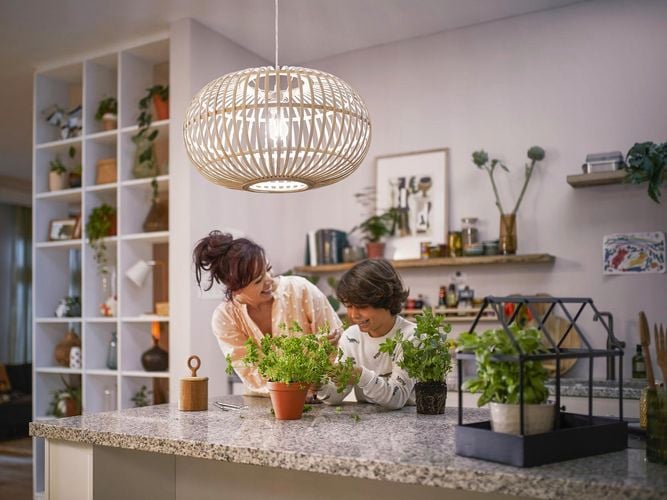 A lady and a young boy standing in the kitchen laughing