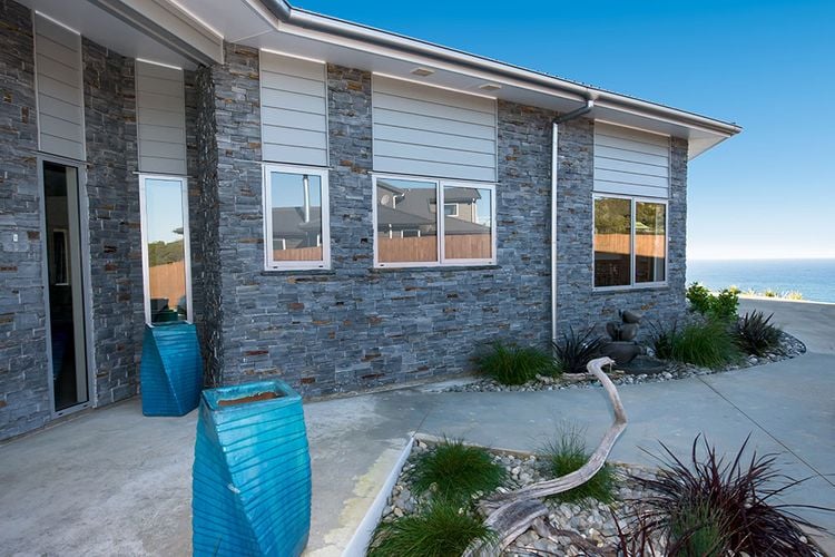 House exterior with sculptures and drainage pipe