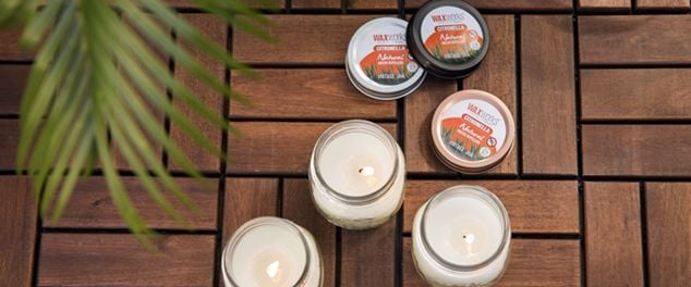 Three insect repellent candles in bowls on a deck