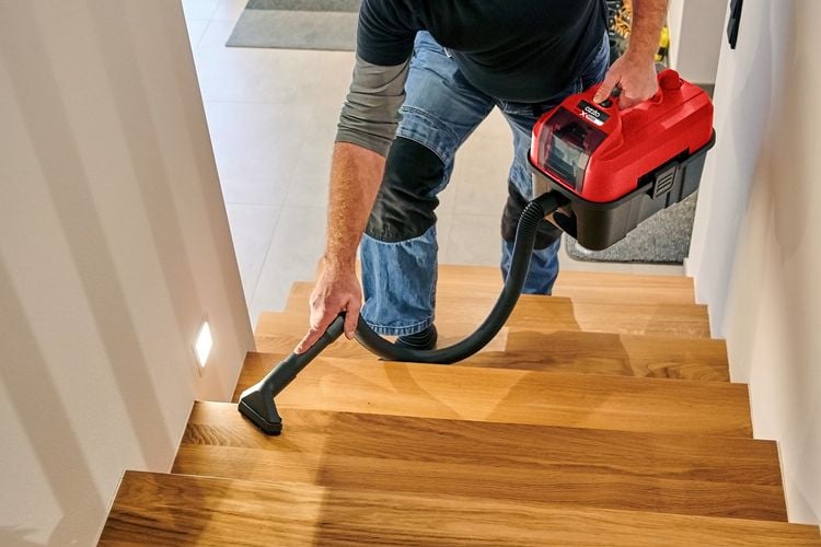 Person using cordless vacuum to clean stairs