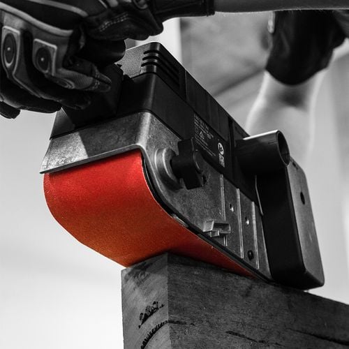 Person using powered sander to sand timber