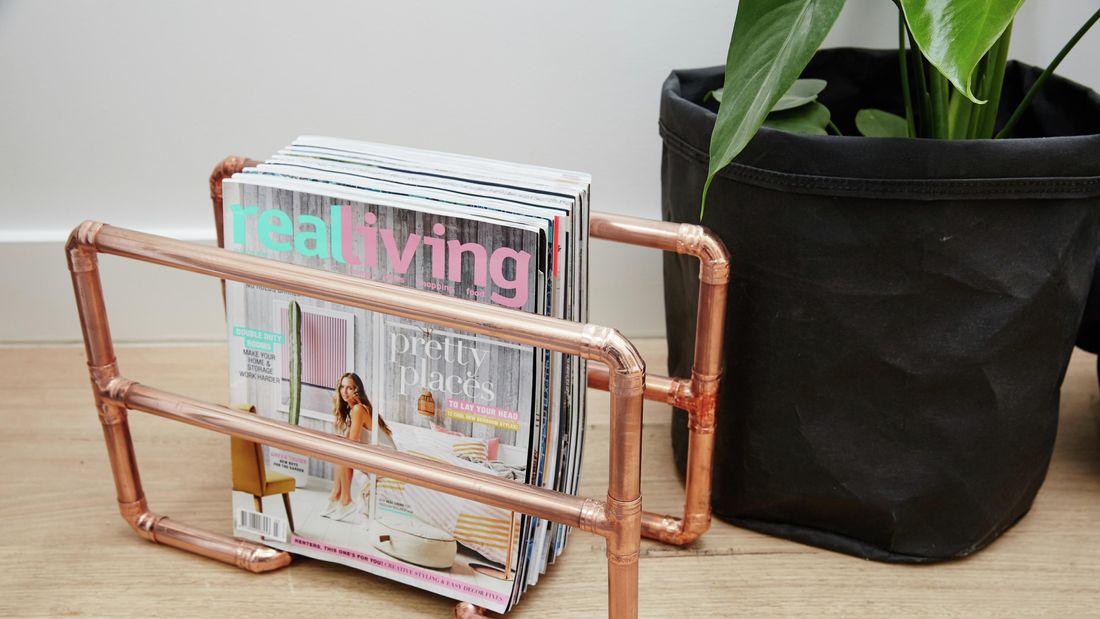 A magazine rack made from polished copper pipe