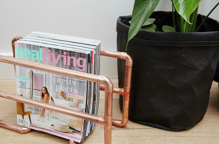 A magazine rack made from polished copper pipe